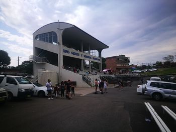 People on road against sky in city