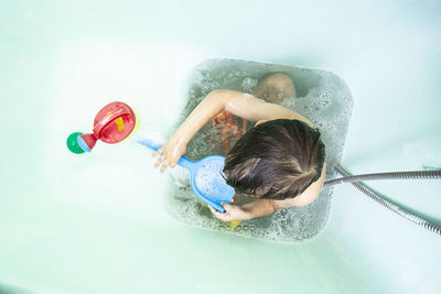 High angle view of shirtless boy in swimming pool