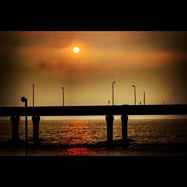 sunset, water, silhouette, sea, sky, scenics, tranquil scene, tranquility, pier, orange color, sun, beauty in nature, horizon over water, built structure, reflection, railing, nature, idyllic, connection, architecture