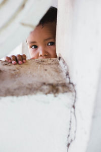 Portrait of cute boy peeking at home