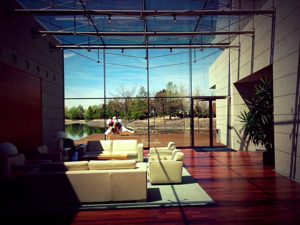 indoors, table, chair, window, glass - material, built structure, architecture, transparent, men, sitting, restaurant, person, tree, day, leisure activity, empty, lifestyles, sunlight, potted plant