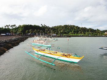 Boats moored in sea against sky