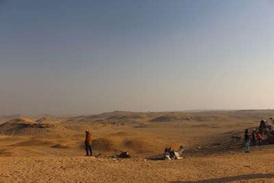 People standing in desert against sky