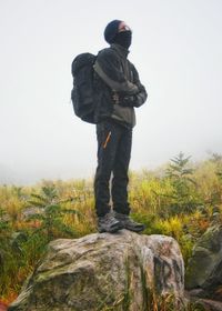 Rear view of man standing on field against sky