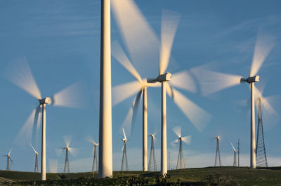 Windmills on field against sky