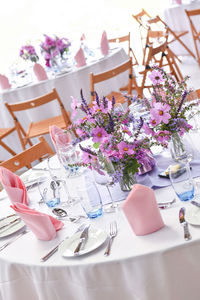 Wide view of table at formal dinner party venue with napkins and glasses