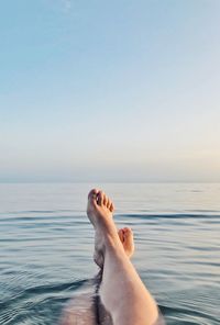 Low section of man relaxing in swimming pool