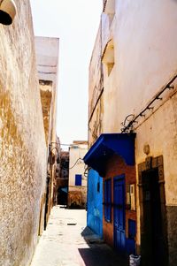 Alley amidst buildings in city against sky