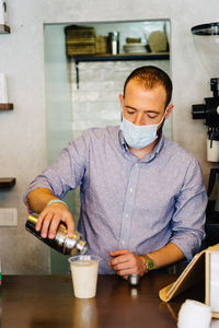 Portrait of young barista preparing a cappuccino