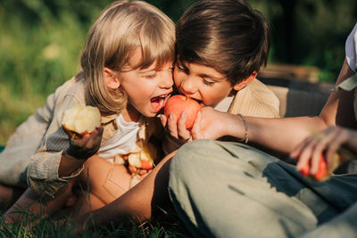 Side view of boy eating food at park