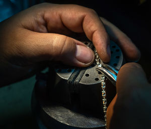 Midsection of person working on metal