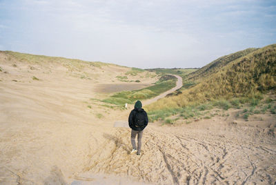 Rear view of man walking on mountain