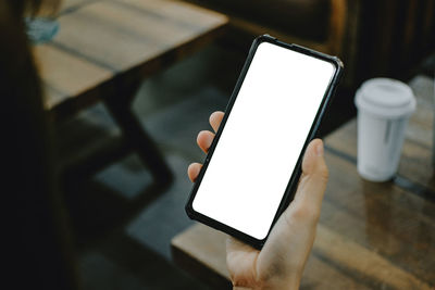 Low angle view of person using smart phone on table