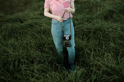 Woman is holding an anlog camera.