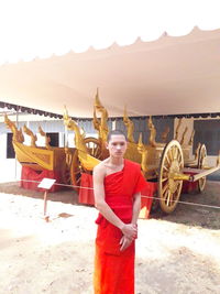 Portrait of young man standing against built structure