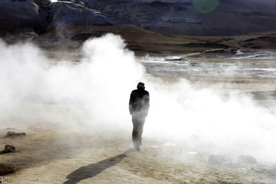 Rear view of man hiking at volcanic landscape