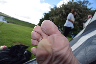 Low section of person in tent with woman in background