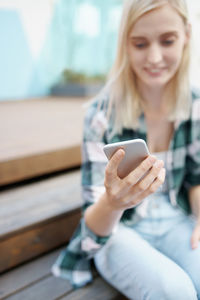 Smiling young woman using mobile phone