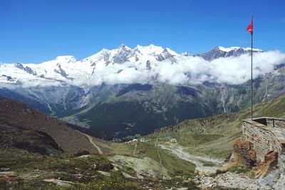 Scenic view of snowcapped mountains against clear blue sky