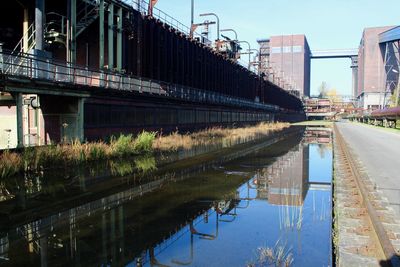 Bridge over river in city against sky