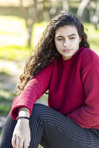 Thoughtful teenage girl sitting in park