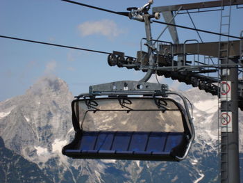 Ski lift over snowcapped mountains against sky