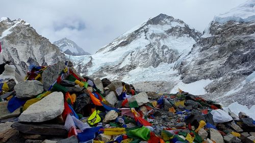 Prayer flags on rocks against snowcapped mountains