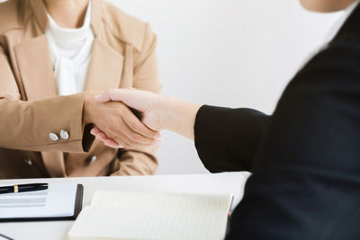 Midsection of woman with hands on table