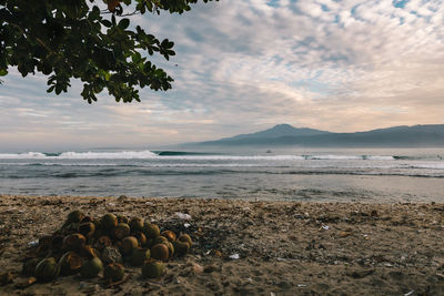 Scenic view of sea against cloudy sky during sunrise