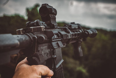 Cropped hand of man holding gun