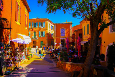 People on street amidst buildings in city