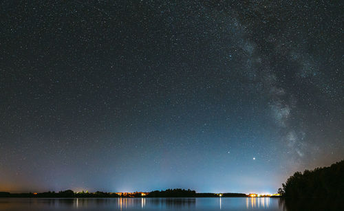 Scenic view of lake against sky at night