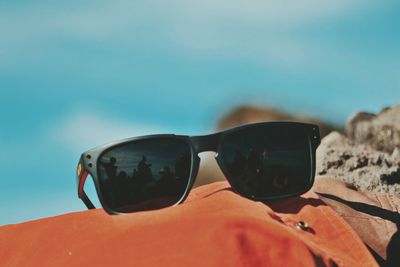 Close-up of sunglasses on beach against sky