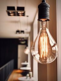 Close-up of illuminated light bulb at home