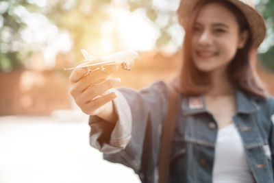 Portrait of a smiling young woman holding outdoors