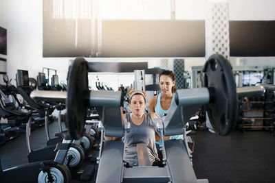 Instructor getting woman trained in gym