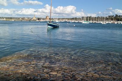 Sailboats moored in sea against sky