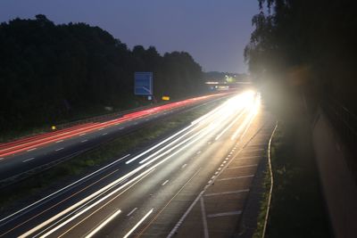 Light trails on road against sky in city
