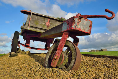 Close-up of machinery on field against sky