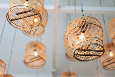 Low angle view of illuminated light bulb hanging on ceiling