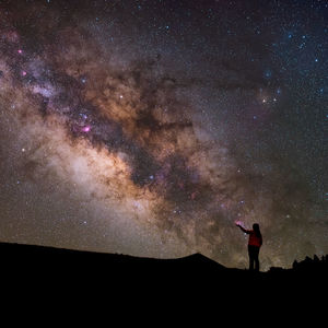  woman standing against star field at night