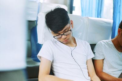 Young man sleeping on seat in bus