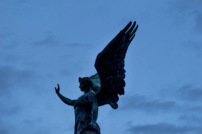 Low angle view of angel statue against sky