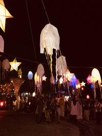 Group of people against illuminated buildings at night