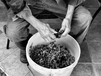 High angle view of man preparing grapes