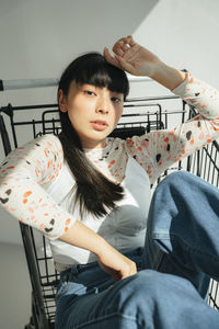 Portrait of woman sitting on chair at home