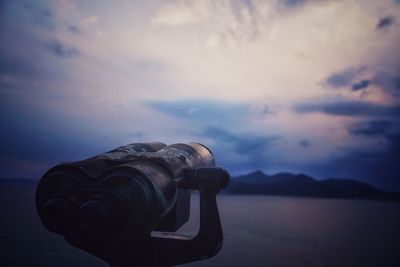 Close-up of coin-operated binoculars against sky