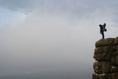 People standing on rock against sky