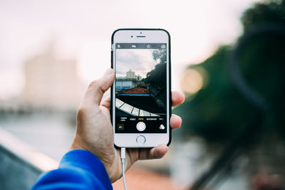 Close-up of person photographing mobile phone