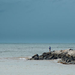 Man standing on beach against clear sky